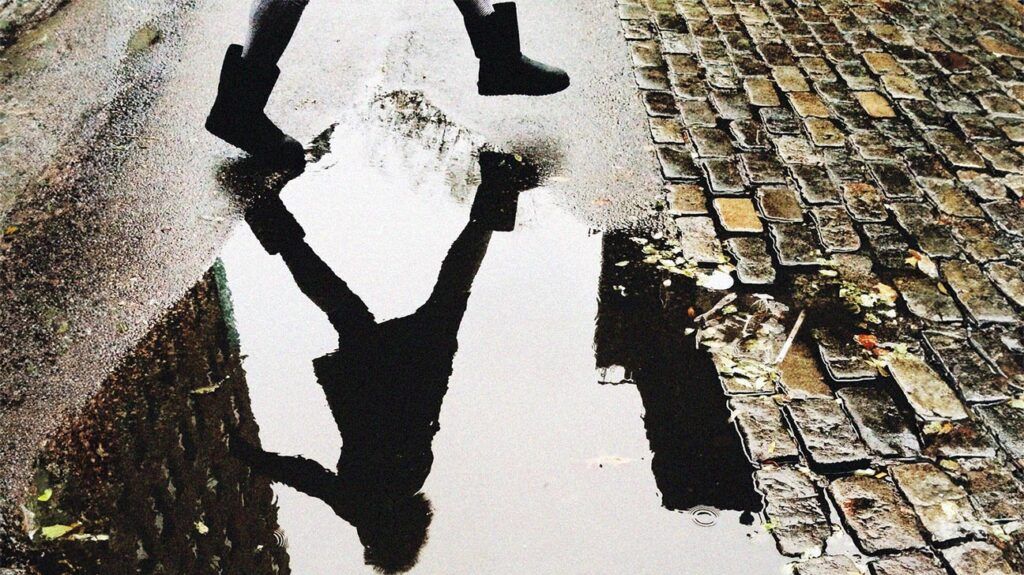 a person is walking over a puddle