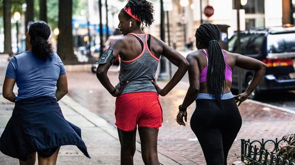 Group of female runners walking through urban area