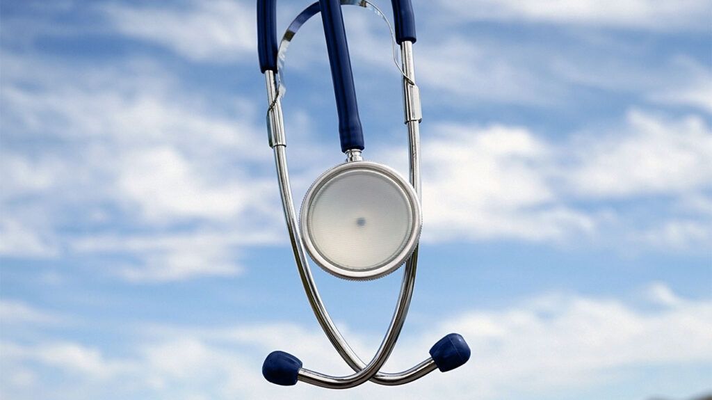A stethoscope in front of a cloudy sky background.