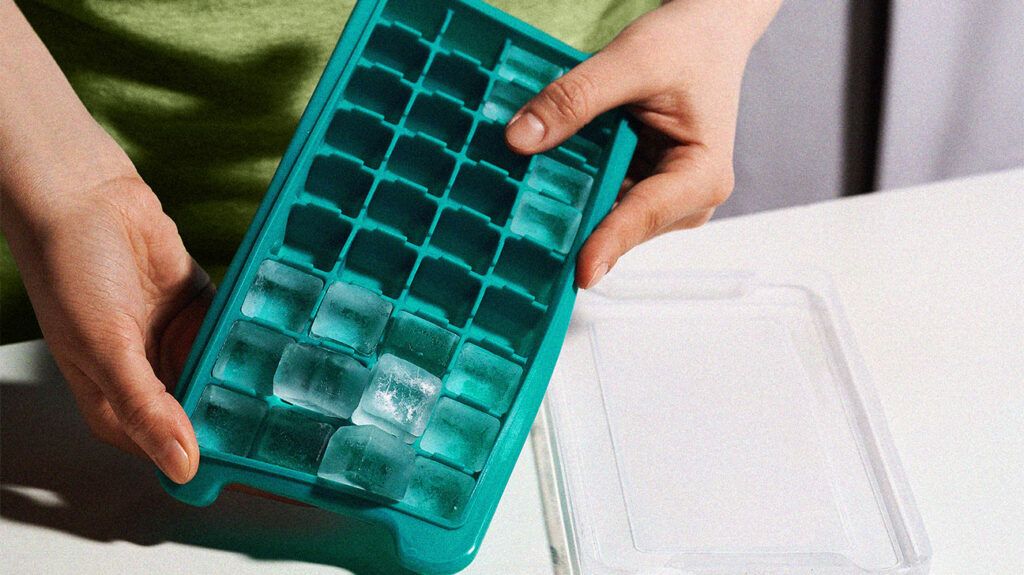 A person pushing ice cubes out of a tray to use for tendinitis inflammation.