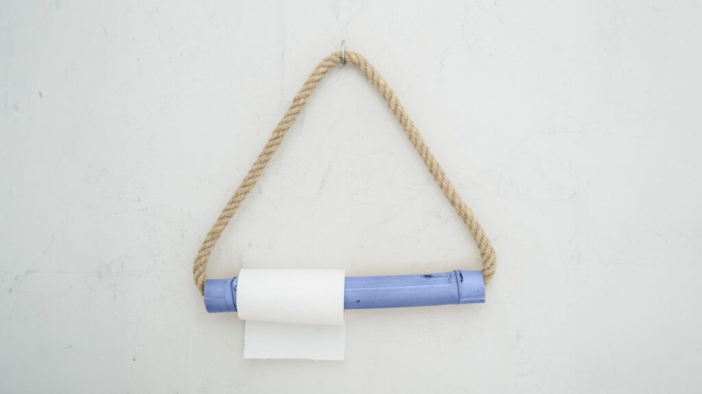 Toilet roll hanging on a triangular holder against a white background -1.
