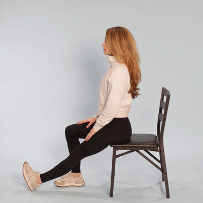 Female sitting in a chair demonstrating a single leg hamstring stretch
