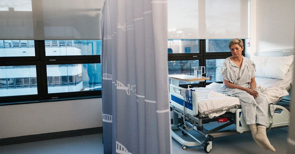 A person with endometrial cancer sitting on a hospital bed waiting for brachytherapy treatment.-2