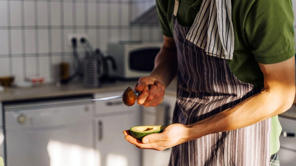 person cutting avocado