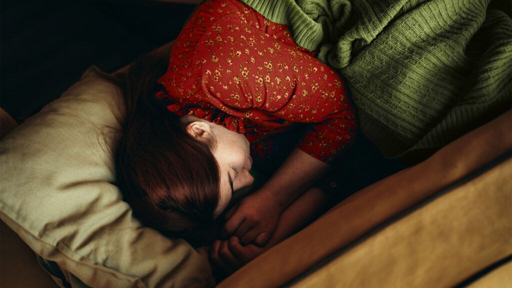Female sleeping in a wood frame bed