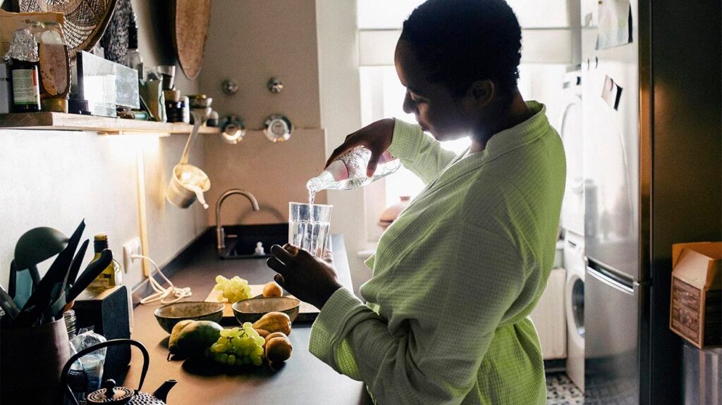 Female in a kitchen pouring a glass of water