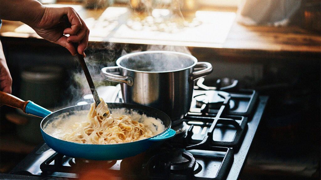 A person preparing a pasta dish which may be a reason that are not losing weight on keto -2.
