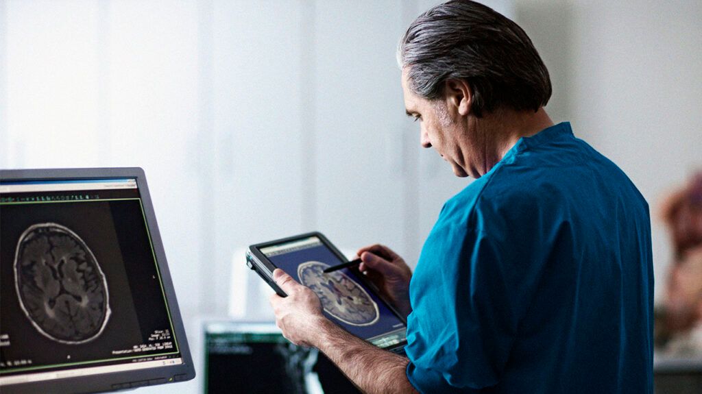 Doctor looking at MRI scan on portable computer-1