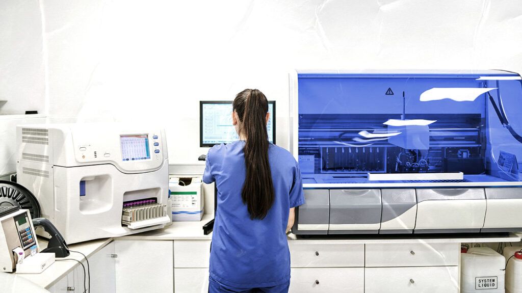 A medical professional is looking at a computer.