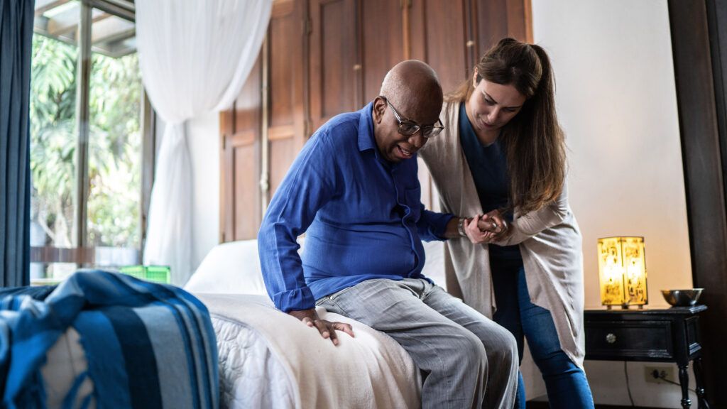 Older male being assisted by a nurse