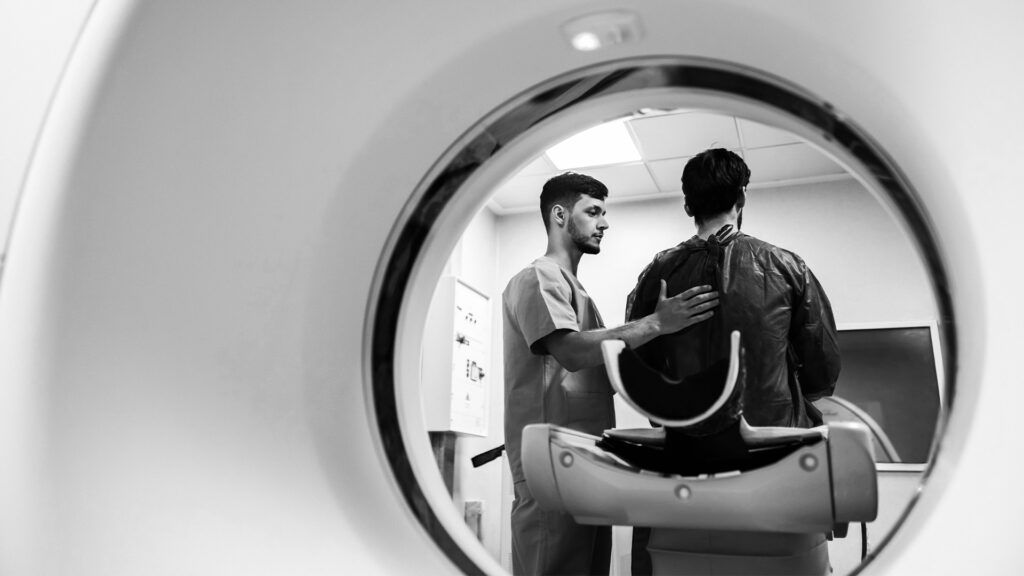 Black and white image of a person getting ready to have an MRI scan