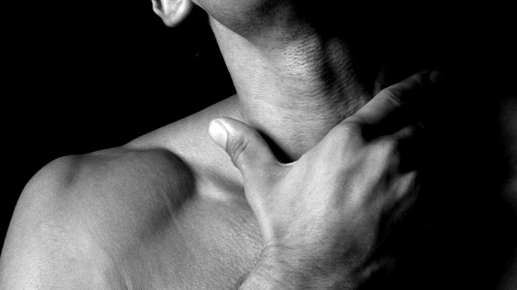 A man touching his throat. -1