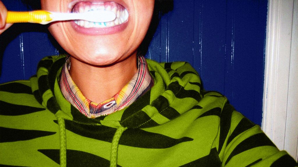 Close up of a person brushing their teeth.