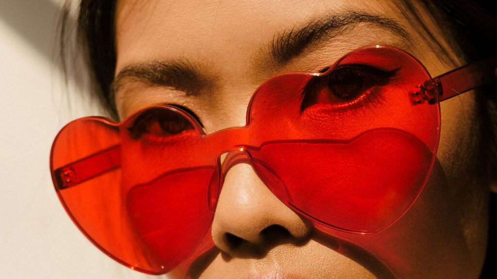 there is a close up of a woman looking through heart shaped glasses
