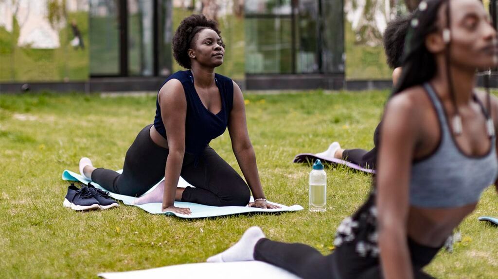 A woman doing yoga in a park to ease symptoms of groin and leg pain -2.