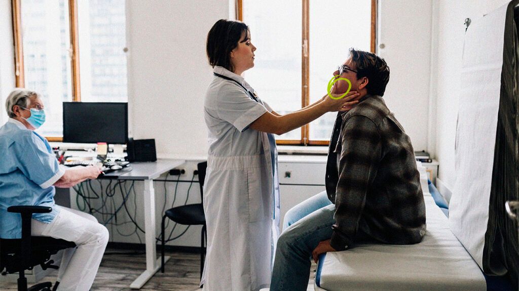 Healthcare professional checking a person's face and neck