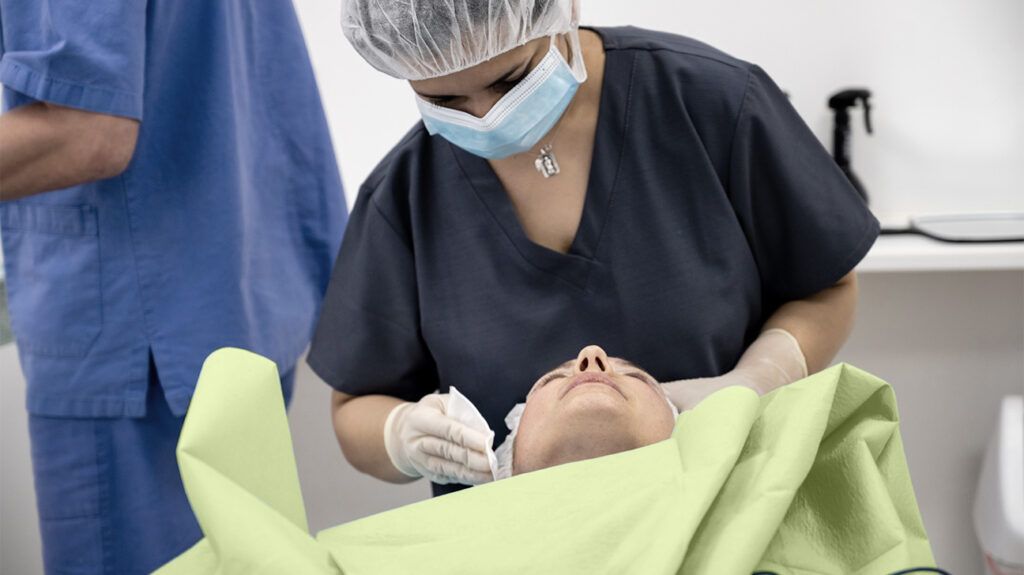 A medical professional is examining a person's head.