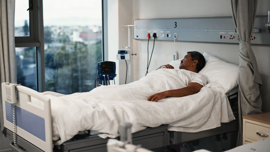 a man is lying in a hospital bed