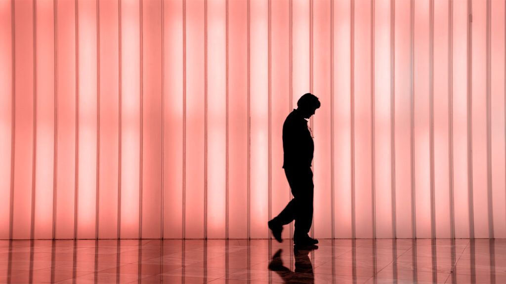 Silhouette of a male against an orange lighted background