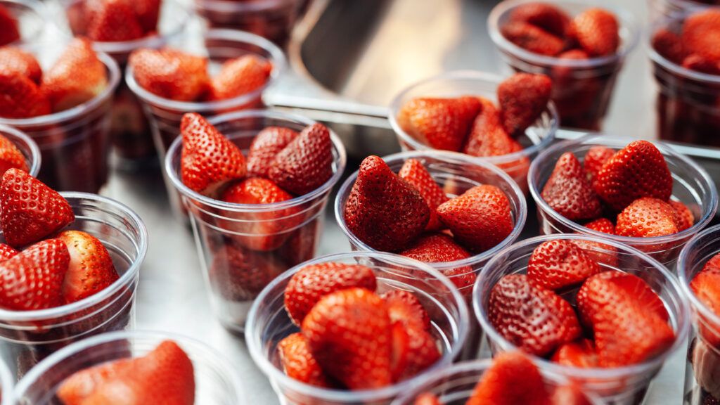 Sliced fresh strawberries in plastic cups