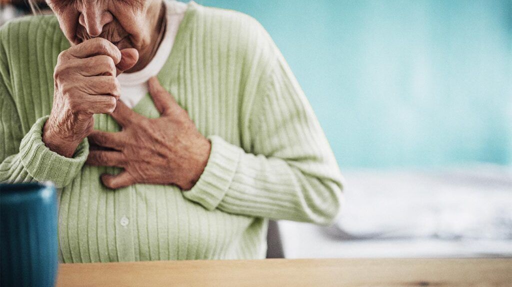 an older woman is coughing