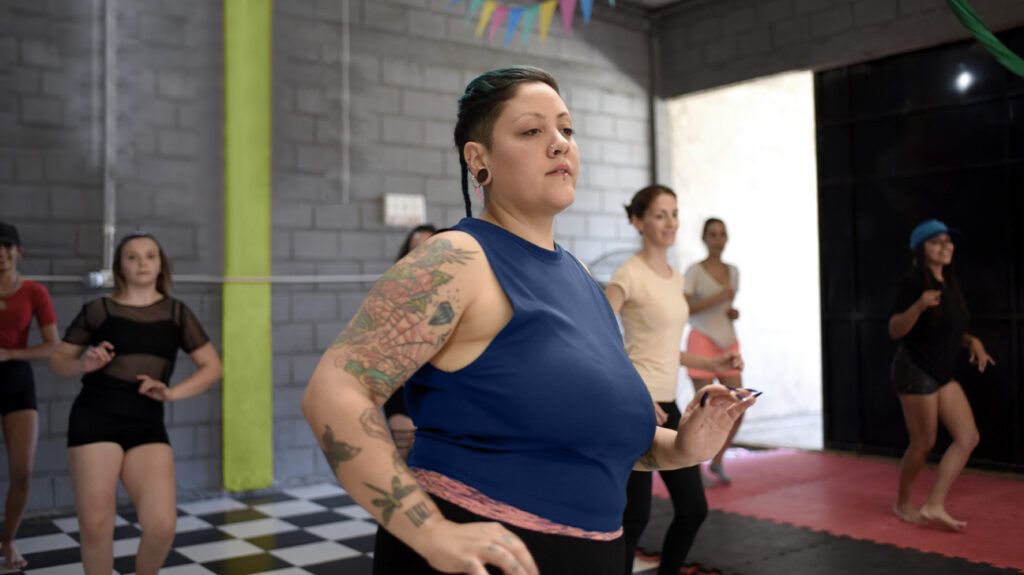 A person with tattoos on their arm exercising 1