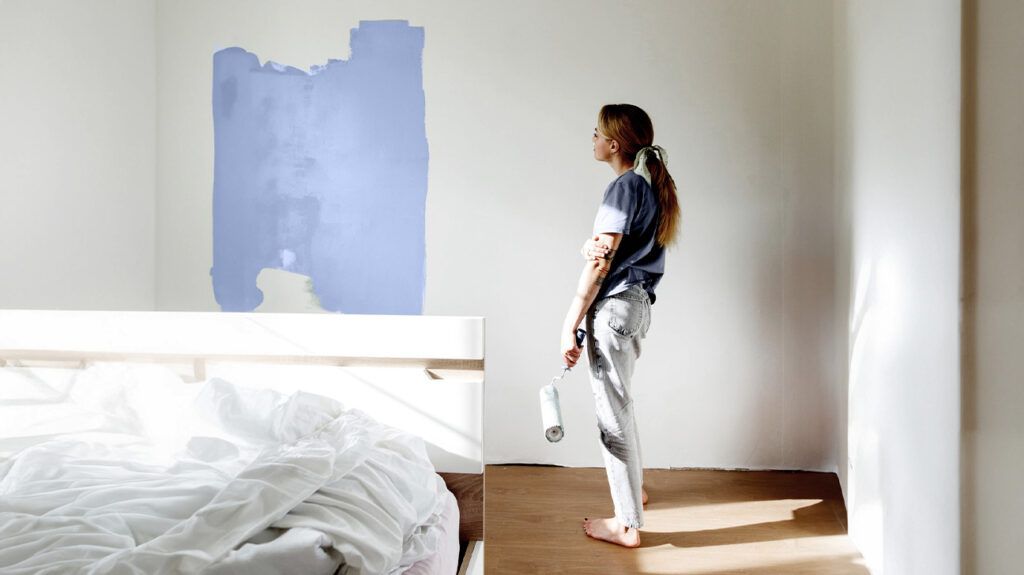 Female standing in front of a partially painted wall