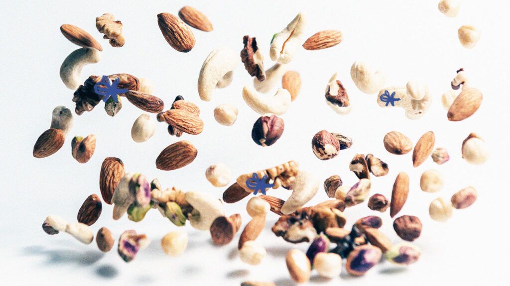 A selection of nuts falling against a white background.-2
