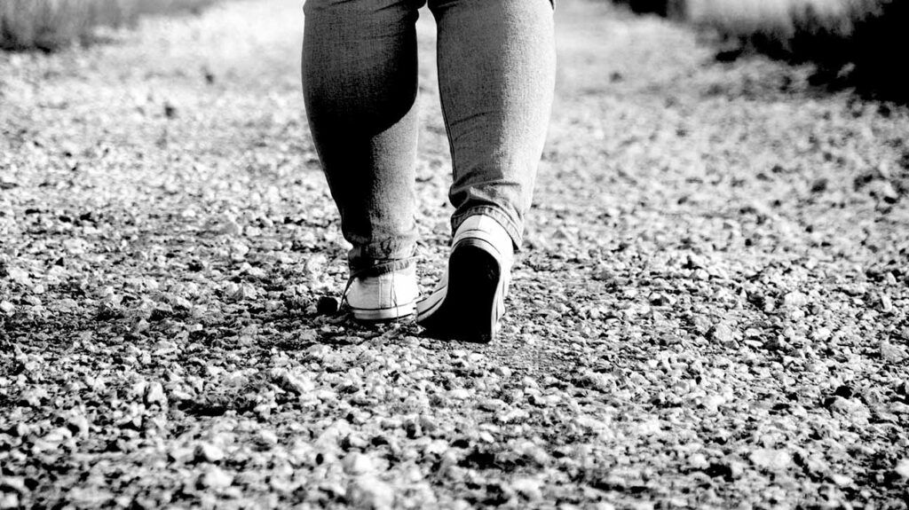 feet walking on a gravel path