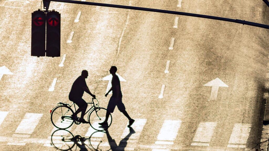 ciclista e pedone sulle strisce pedonali