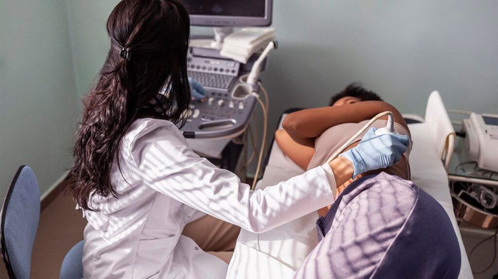Healthcare professional performing an ultrasound on a female