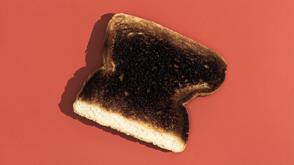 A piece of burnt toast against a red background -1.
