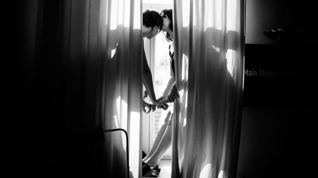 Silhouette of a couple behind sheer curtains