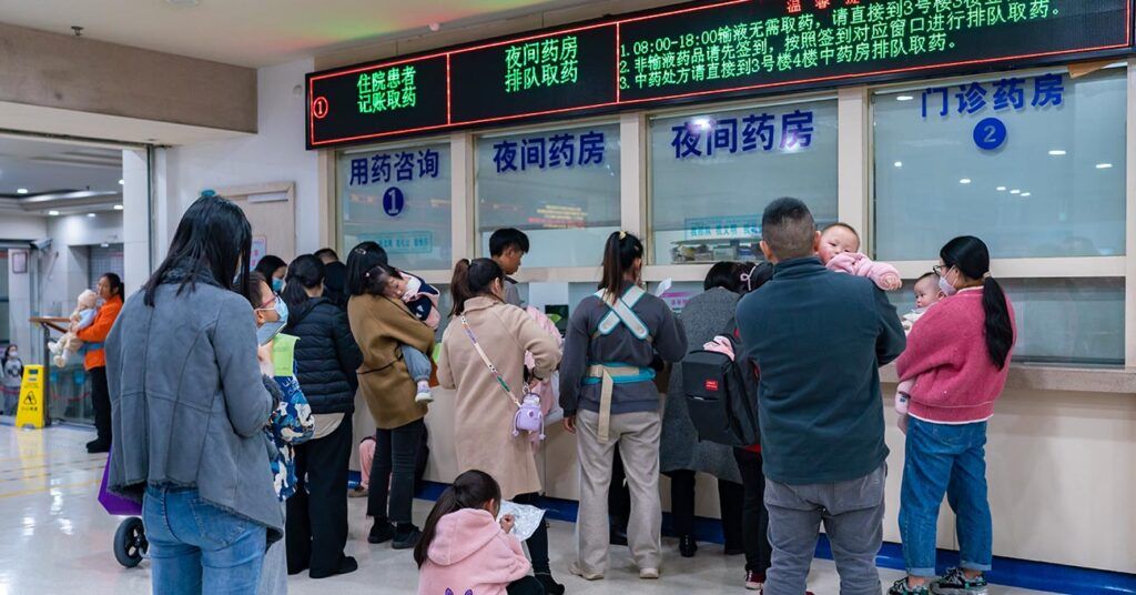 Parents and their children queueing up at a hospital amid a surge in penumonia and respiratory illness in China