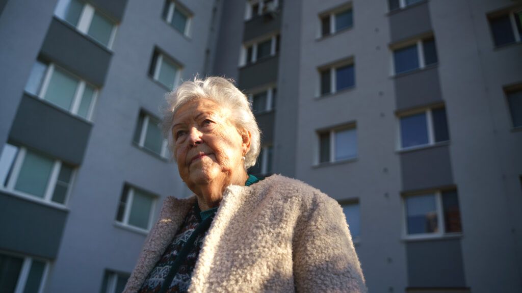Older female in front of a building