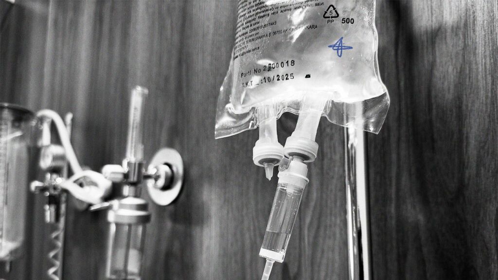 An IV bag and drip with clear liquid inside. -2