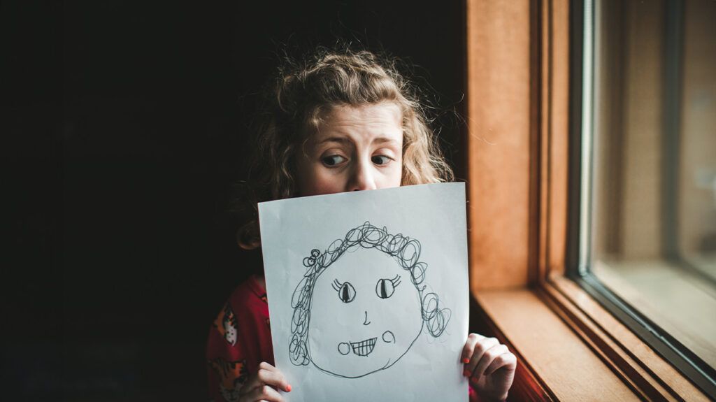 A child holding up a drawing 1