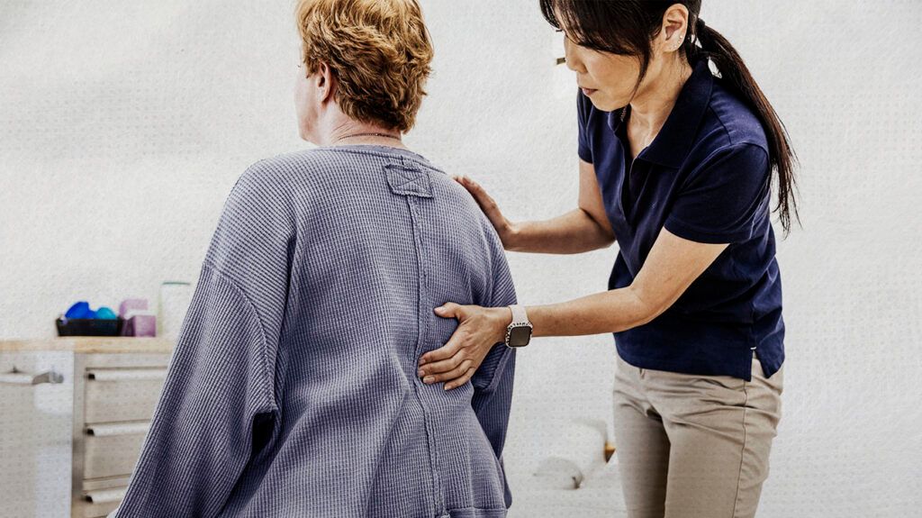 A doctor examining a person with back pain after a fall.-2