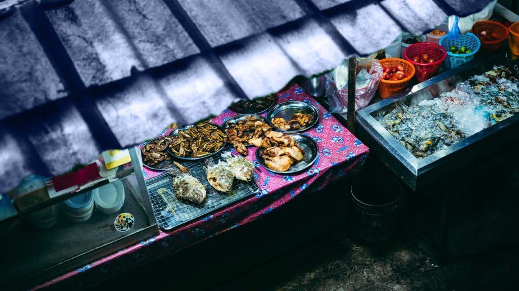 A street food stall featuring various fried fish and meats