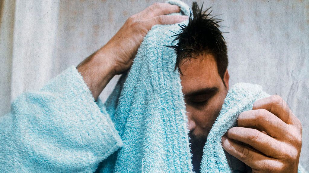 A man drying his face with a towel -2.