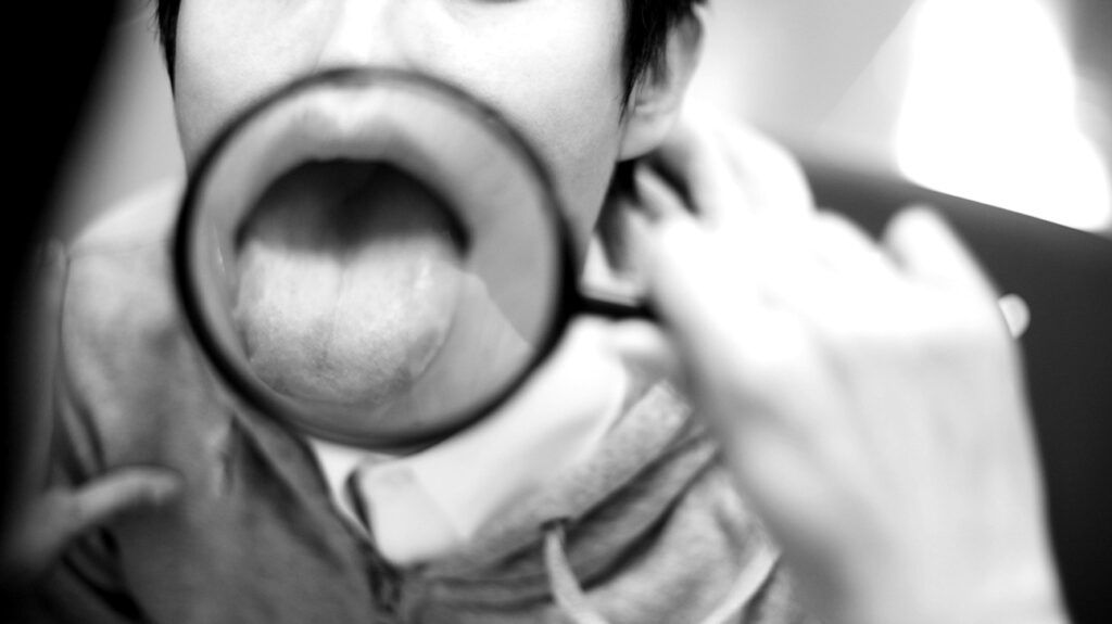 a person is looking at their tongue in a magnified mirror