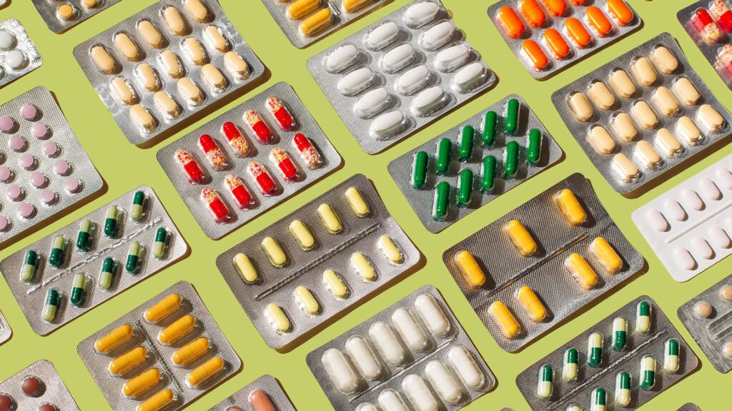 Various packs of vitamins against a green background