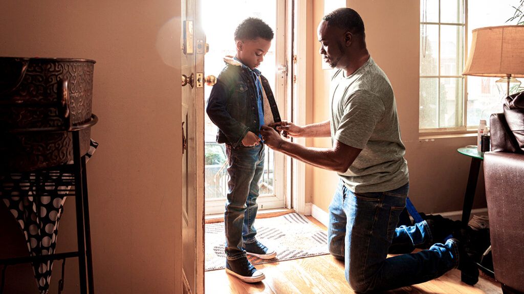 A caregiver helping his son get ready to leave the house -1.