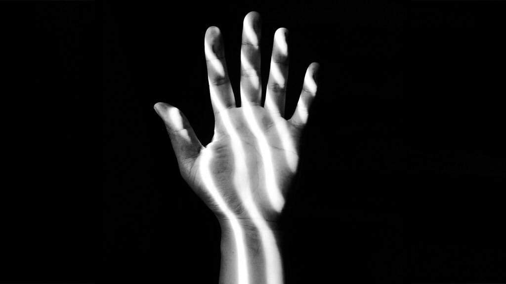 Closeup of a hand in shadows.
