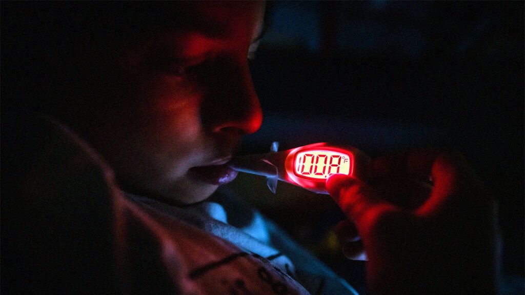 Person taking their temperature in the dark