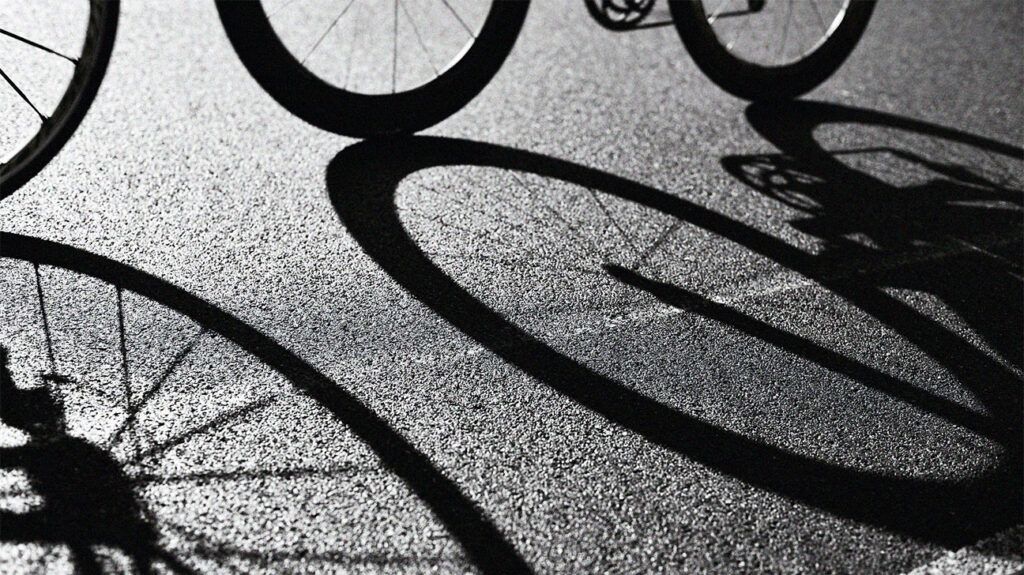 shadow of bike wheels on asphalt