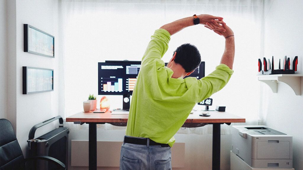 A person working at a standing desk to help prevent carpal tunnel -2