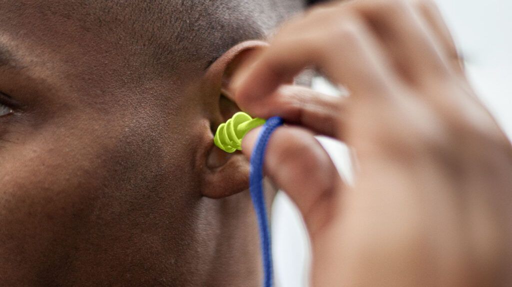 A person with tinnitus putting in an earplug.-1