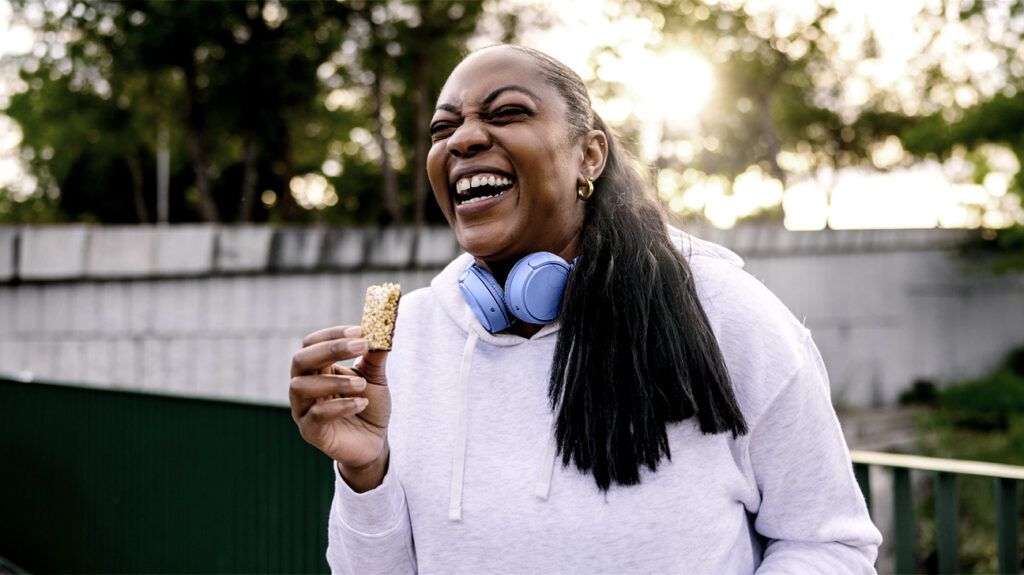 A person laughing while holding a snack 1