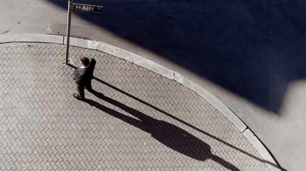 A person with megalophobia on a street with a large shadow behind them.-1